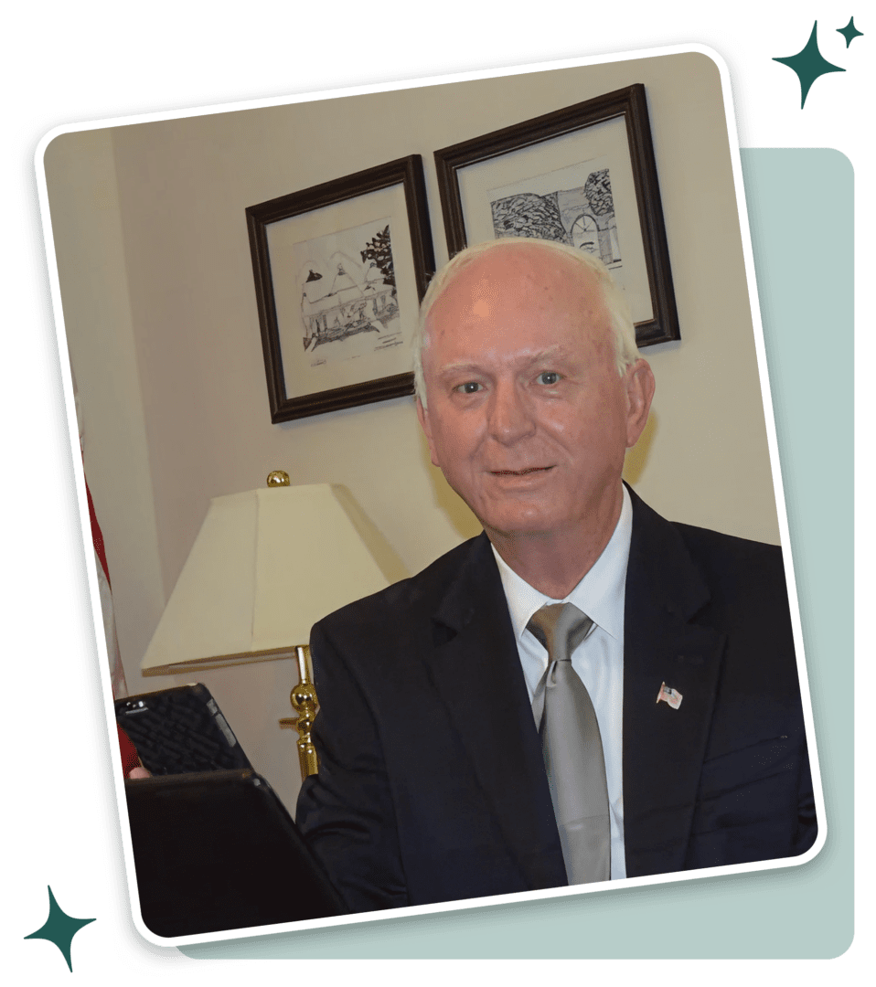 A man in suit and tie sitting at desk.